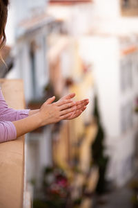 Girl applauding as a show of support for the nurses from the balcony