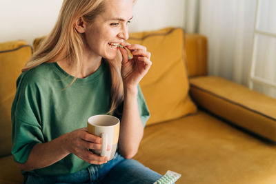 Sick unhappy woman takes a pill. copy space