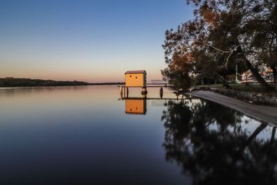 Scenic view of lake against clear sky at sunset