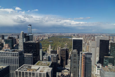 Aerial view of cityscape against cloudy sky