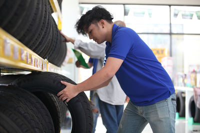 Rear view of men standing by car