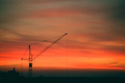 Silhouette electricity pylon against sky during sunset