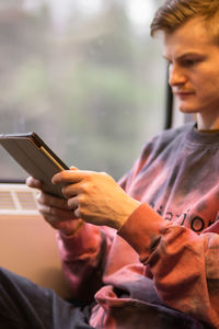 Man reading e-book when he traveling by train. man sits at the train window and using digital tablet