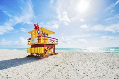 Lifeguard hut at beach against sky during sunny day