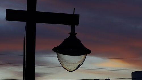 Close-up of hanging light against sky during sunset