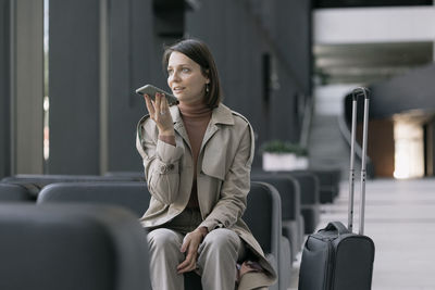 Woman talking on speaker phone in lobby