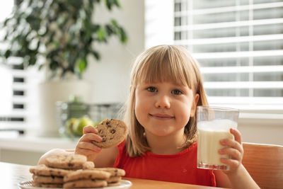 Portrait of young woman having food at home