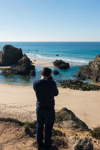 Rear view of man looking at sea shore