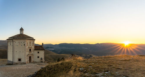 Scenic view of building against clear sky during sunset