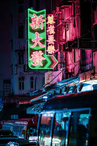 Low angle view of illuminated street light against building at night