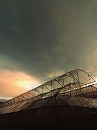 Low angle view of silhouette construction against sky during sunset