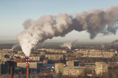 Smoke emitting from chimney against sky