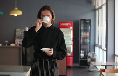 Full length of man holding coffee cup