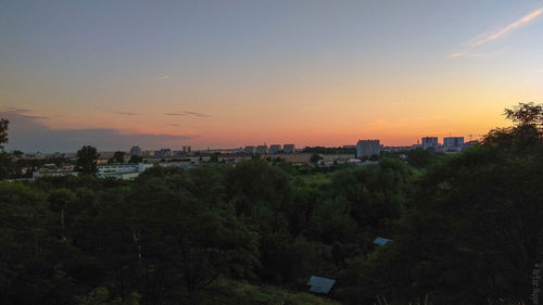 High angle view of trees and buildings against sky during sunset