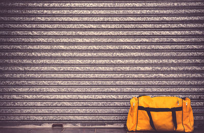 Close-up of bag against corrugated iron