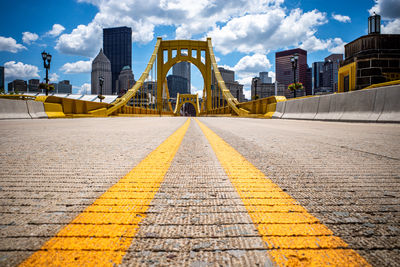 The rachel carson bridge spans allegheny river with road markings with backdrop of pittsburgh.