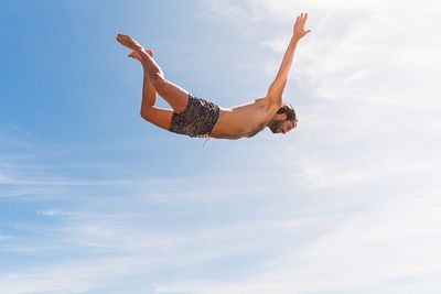 Low angle view of young woman against sky