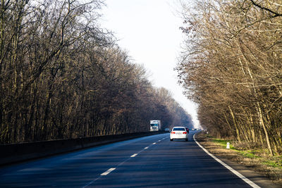 Road amidst trees against sky