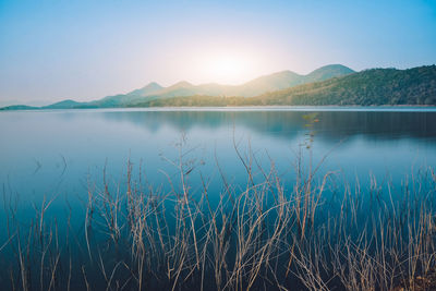 Scenic view of lake against blue sky during sunset