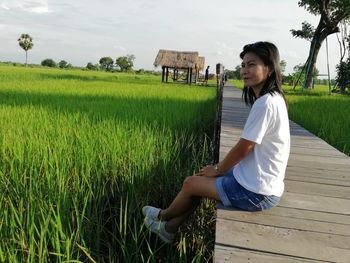 Side view of senior man sitting on field