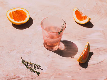 Grapefruit juice and grapefruit around on pink background