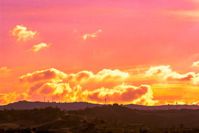 Scenic view of silhouette mountains against orange sky