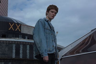 Low angle view of young man standing against sky