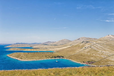 High angle view of sea by mountains against sky
