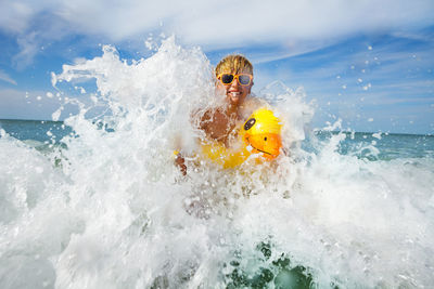 Man surfing in sea against sky