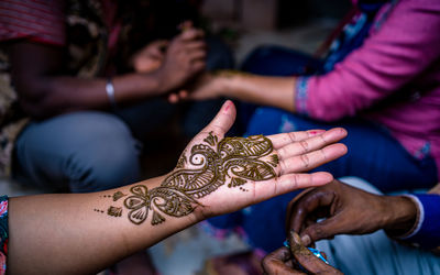 Low section of woman with tattoo on hands