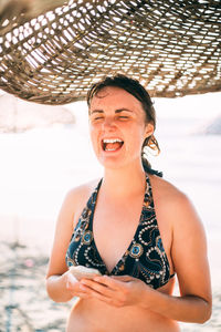 Portrait of young woman wearing hat standing at beach