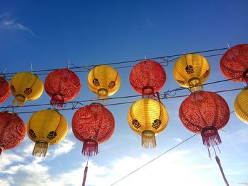 Low angle view of illuminated lanterns hanging against sky