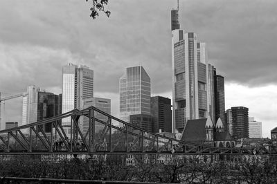 Modern buildings in city against cloudy sky