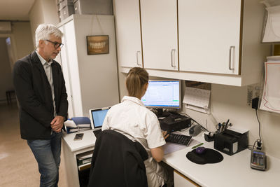 Dentist using computer in surgery