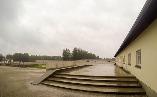 Empty road amidst buildings against sky