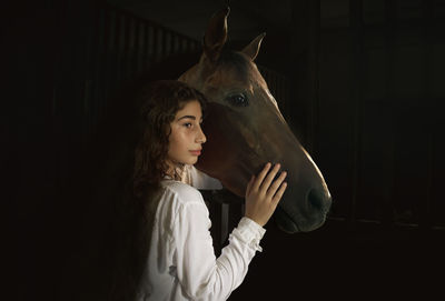 Portrait of young woman holding horse