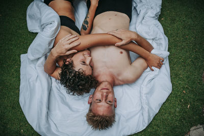 High angle view of couple lying on grass