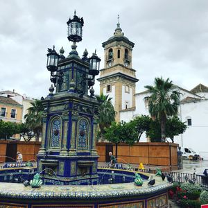 Fountain in front of building against sky