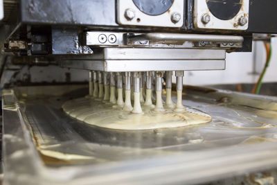 Industrial machine pouring remains of chocolate on a tray in a chocolate factory