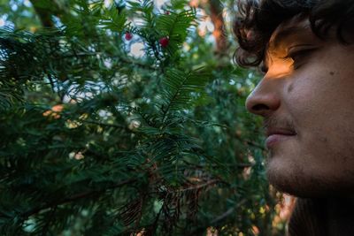 Close-up of young man by tree