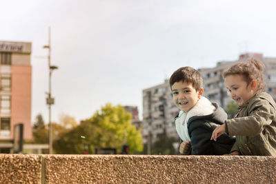 Portrait of happy friends against sky