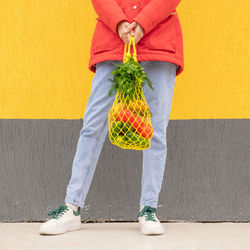 Low section of woman standing against wall