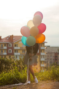 Multi colored balloons on street against sky