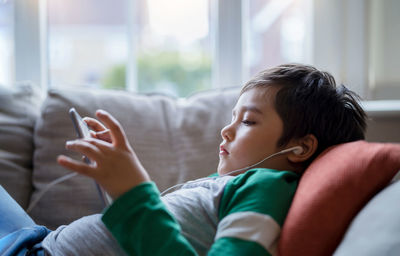 Rear view of boy looking at mobile phone