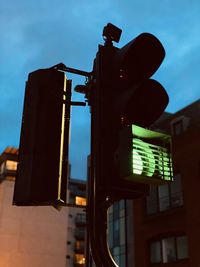 Low angle view of road signal against sky