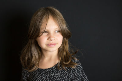 Portrait of a smiling young woman against black background