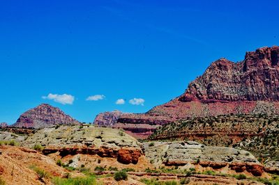 Low angle view of rocky mountain against blue sky