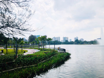 Scenic view of river by city against sky