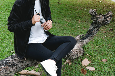 Midsection of man using mobile phone in field