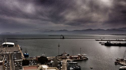 Boats moored at harbor against sky